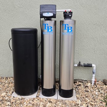 Stainless twin-tank whole home system installed beside a home