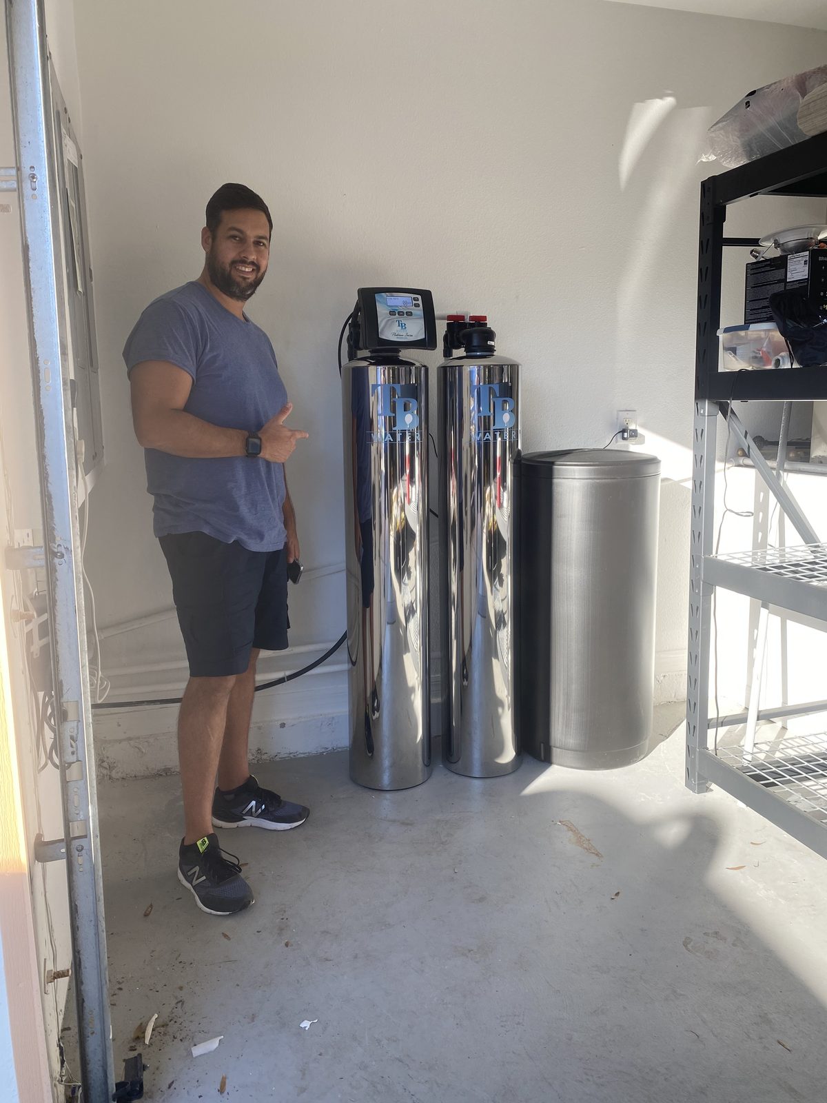 Customer giving a thumbs up next to his new TB Water twin tank system