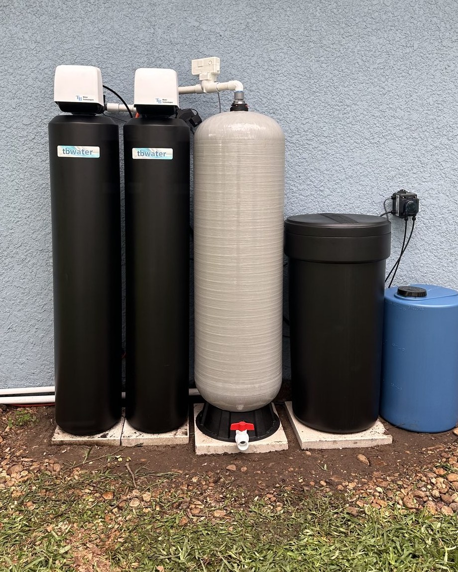 Well water treatment system with twin black tanks, retention tank and peroxide solution tank installed outside a Tampa Bay home
